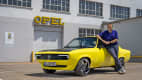 Ein Mann lehnt am Opel Mantra mit Elektroantrieb