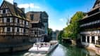 Ein Ausflugsboot auf dem Fluss Ill  der durch das Viertel Petit France in Straßburg fließt