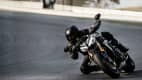 Ein Mann fährt auf dem Motorrad Triumph Speed Triple 1200 RS dynamisch durch eine Kurve.