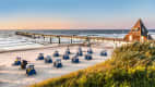 Strandkörbe am Strand der Insel Usedom mit einem langen Steeg
