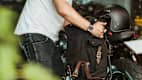 Ein Mann bringt an seinem Motorrad eine Satteltasche an