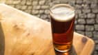 Ein Glas Altbier steht im Abendlicht auf einem Tisch in der Düsseldorfer Altstadt
