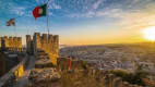 Menschen bewundern den Sonnenuntergang in Saint George Castle