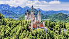 Außenansicht von Schloss Neuschwanstein mit den Alpen im Hintergrund