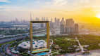 Panoramablick auf den Sonnenuntergang des weltgrößten Rahmens aus Gold in Dubai