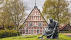 Fachwerkhaus und Statue des Priesters Heinrich von Carsten Eggers in Steinkirchen