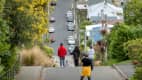 Touristen blicken die steile Baldwin Street in Dunedin New Zealand hinab und machen Fotos