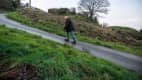 Ein Mann geht die steile Harlech Street in North Wales hinauf