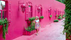 Ein kleines Mädchen läuft an einem pinken viktroianischen Haus entland in Puerto plata in der Domenikanischen Rebublick.