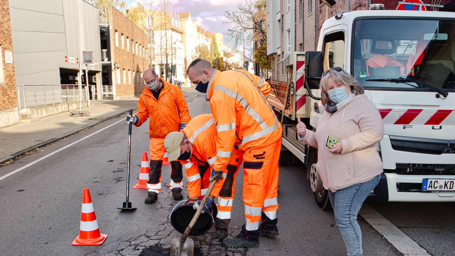 Straßenarbeiter verfüllen ein Schlagloch