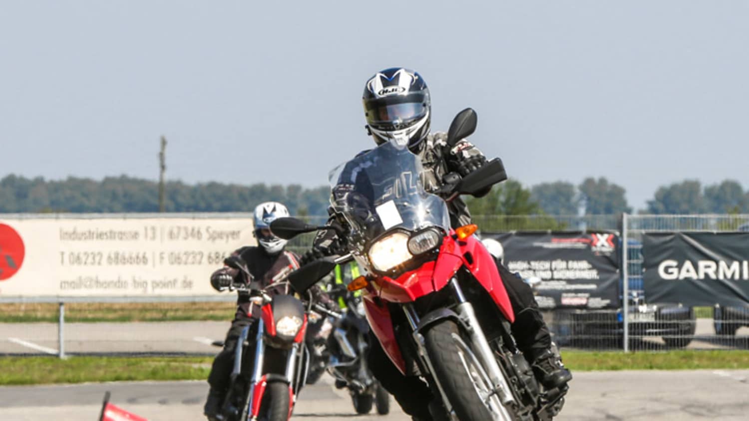 Rotes Motorrad fährt durch Slalomparcours bei ADAC Fahrsicherheitstraining