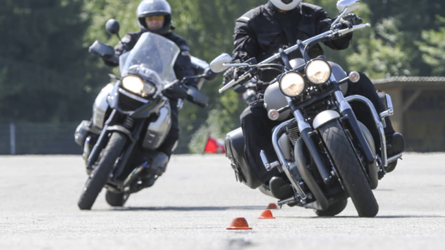 zwei schwarze Motorräder fahren im Slalom bei ADAC Fahrsicherheitstraining