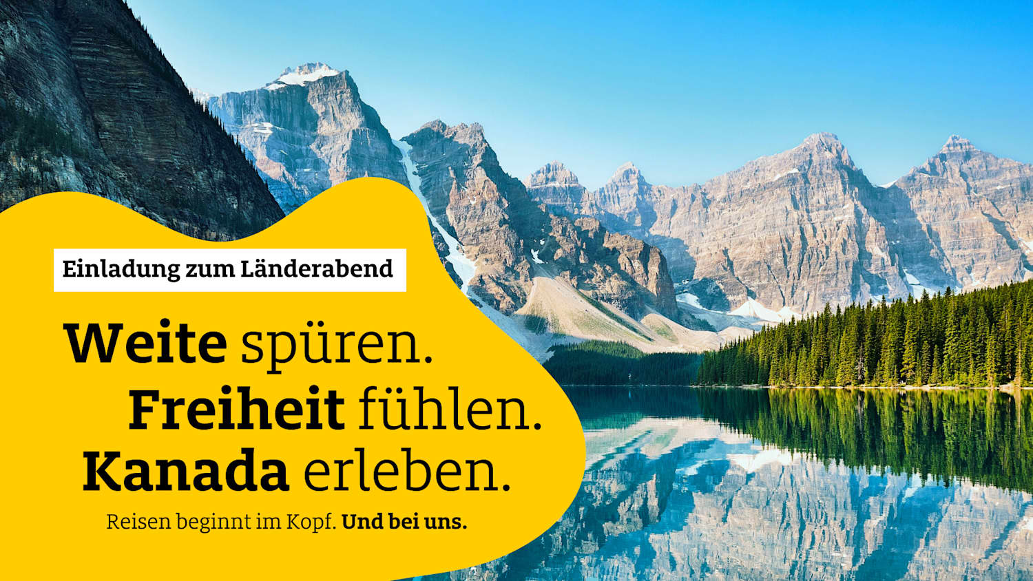 Ein blauer See, gesäumt von Wald, liegt vor schneebedeckten Bergen.