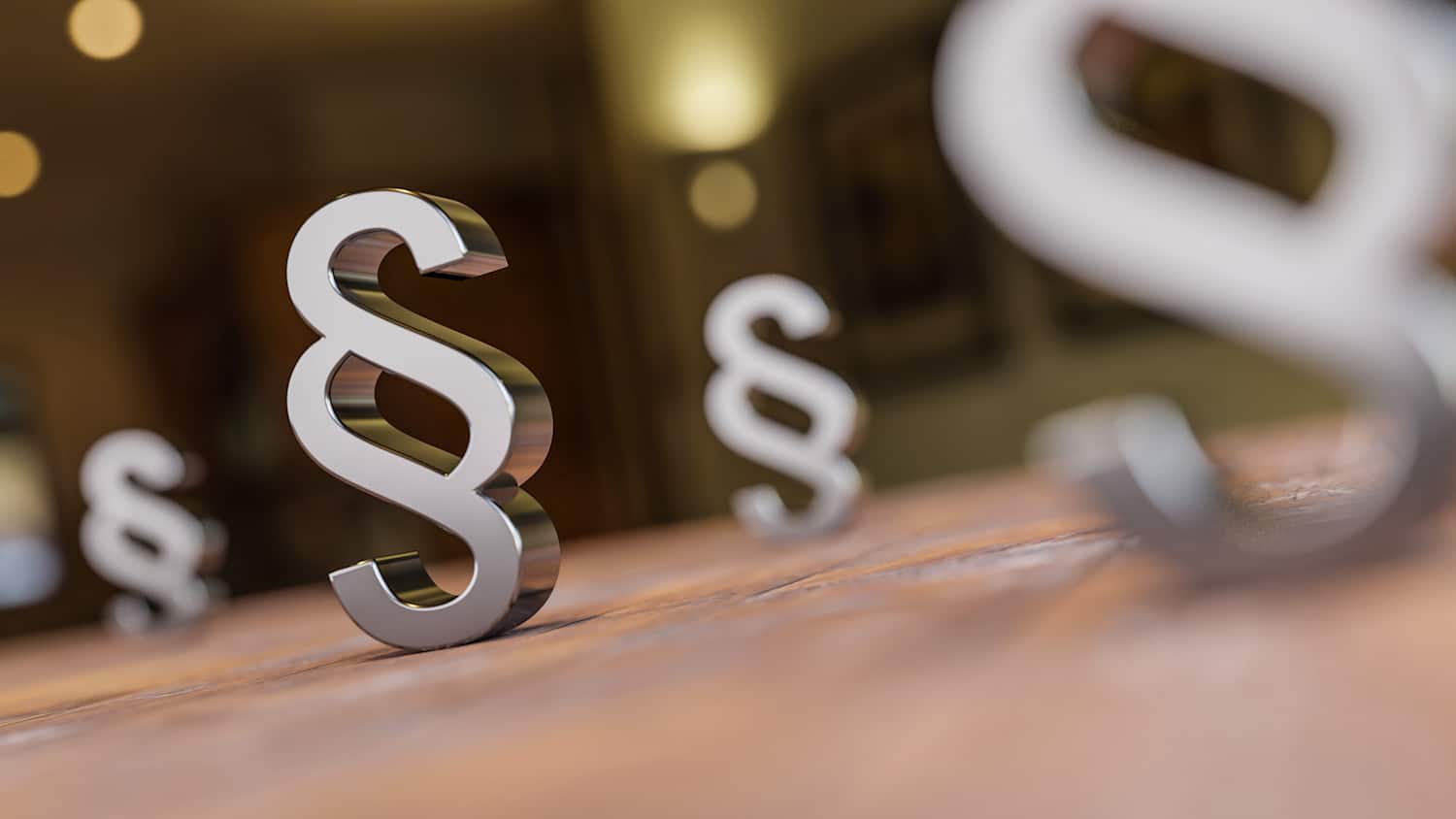 Mehrere Paragraphen-Symbole stehen auf einer braunen Oberfläche.