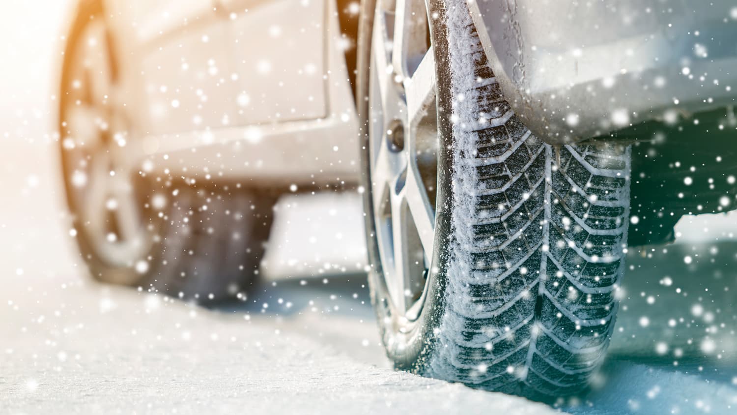 Winterreifen eines grauen Leasing-autos fahren im Schnee.
