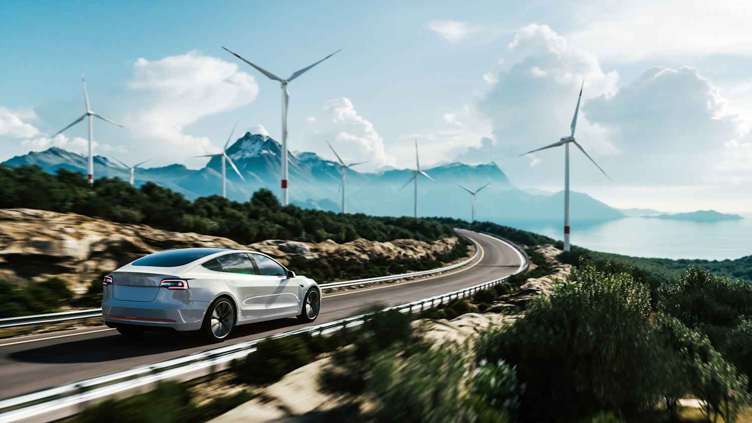 Ein weißes Auto fährt auf einer Straße die Küste entlang durch eine Landschaft aus Bergen und Windrädern, was die Vorteile ein Elektroauto oder Hybridauto zu leasen widerspiegelt.