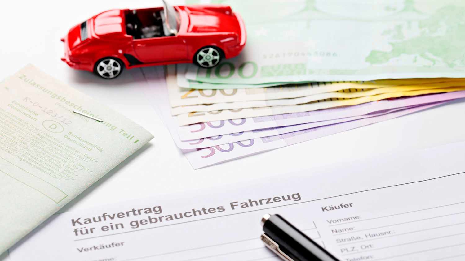 Kaufvertrag für einen Gebrauchtwagen mit Geld und Zulassungsbescheinigung