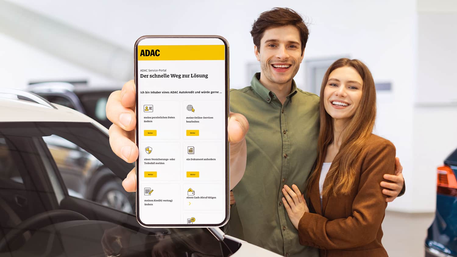 Pärchen im Autohaus zeigt das ADAC Service-Portal auf dem Smartphone
