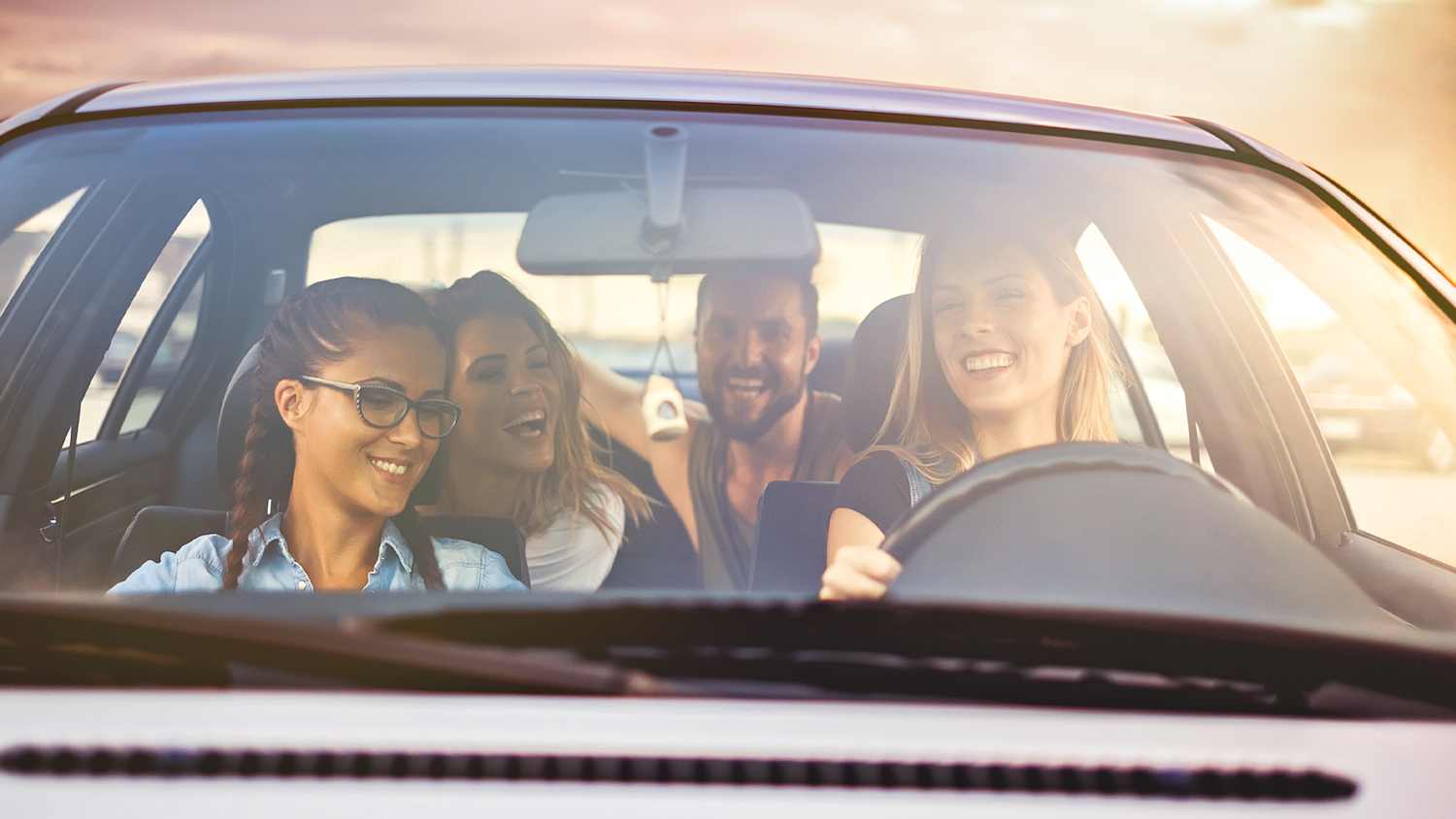 Junge Autofahrer freuen sich dass sie bei der ADAC Autoversicherung sparen können
