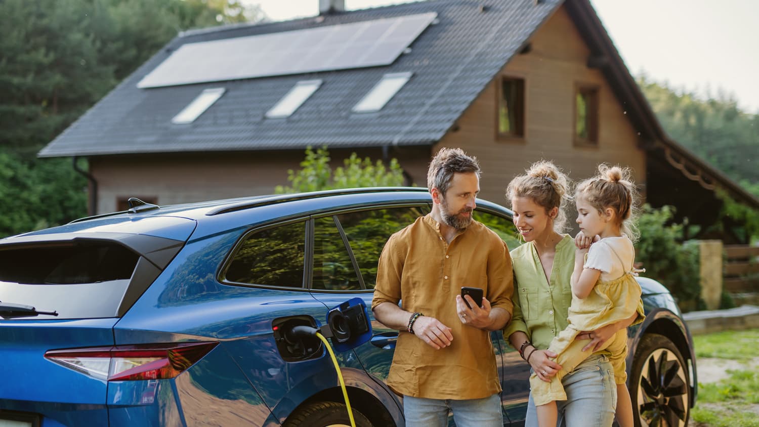 Familie mit Eigenheim und eigenem Solarstrom vom Dach für das E-Auto laden.