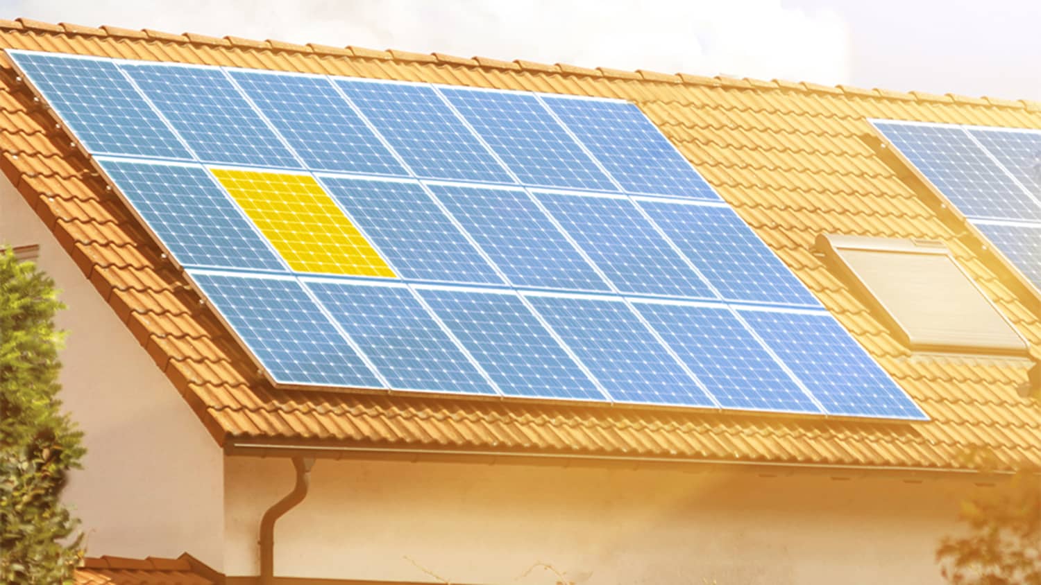 Eine Photovoltaik-Anlage auf dem Dach eines Haus, auf das die Sonne scheint.