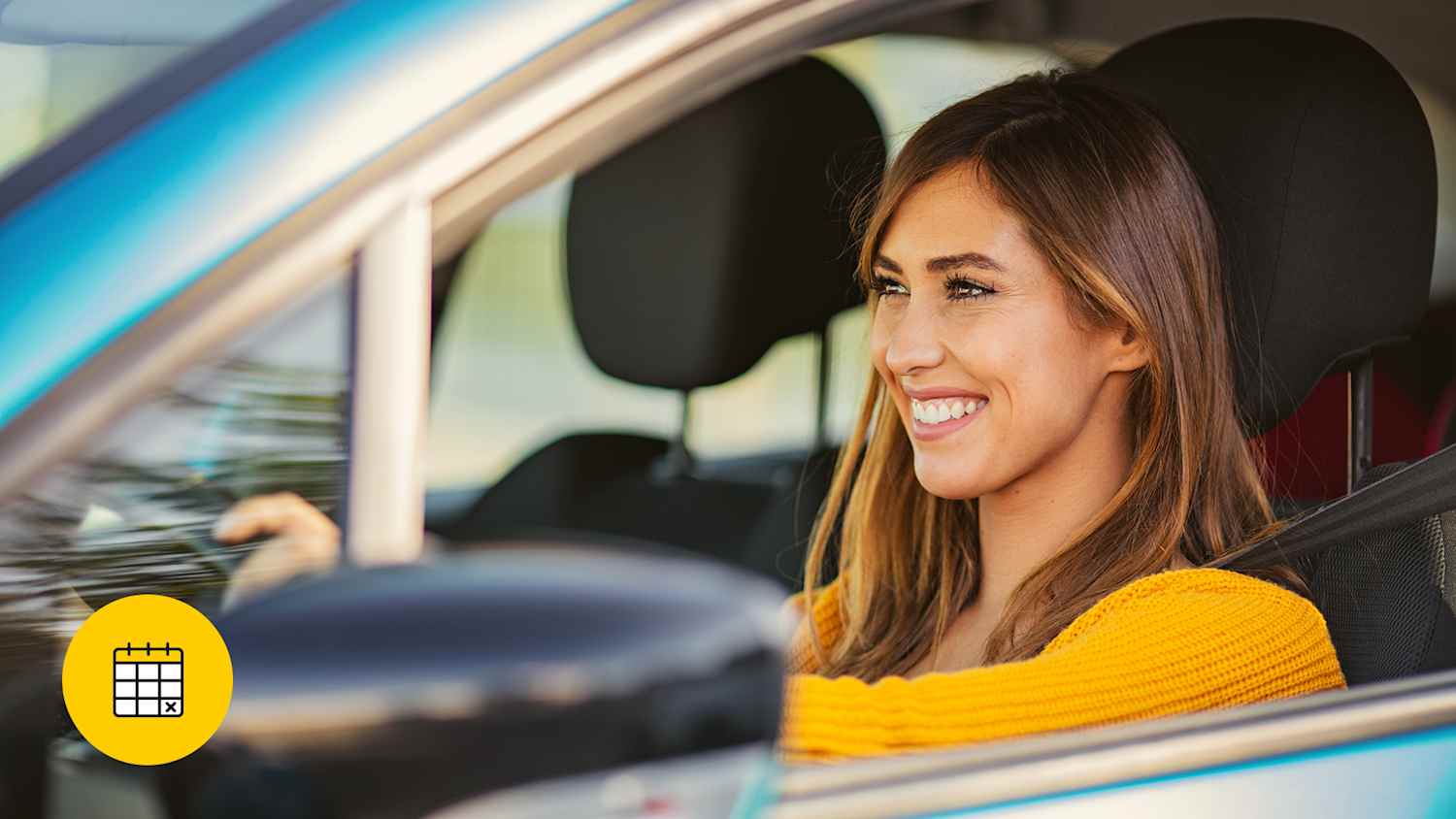 Eine Frau in einem gelben Pullover sitzt lächelnd hinter dem Steuer eines grauen Autos, nachdem sie sich über Laufzeiten bei Leasing informiert hat