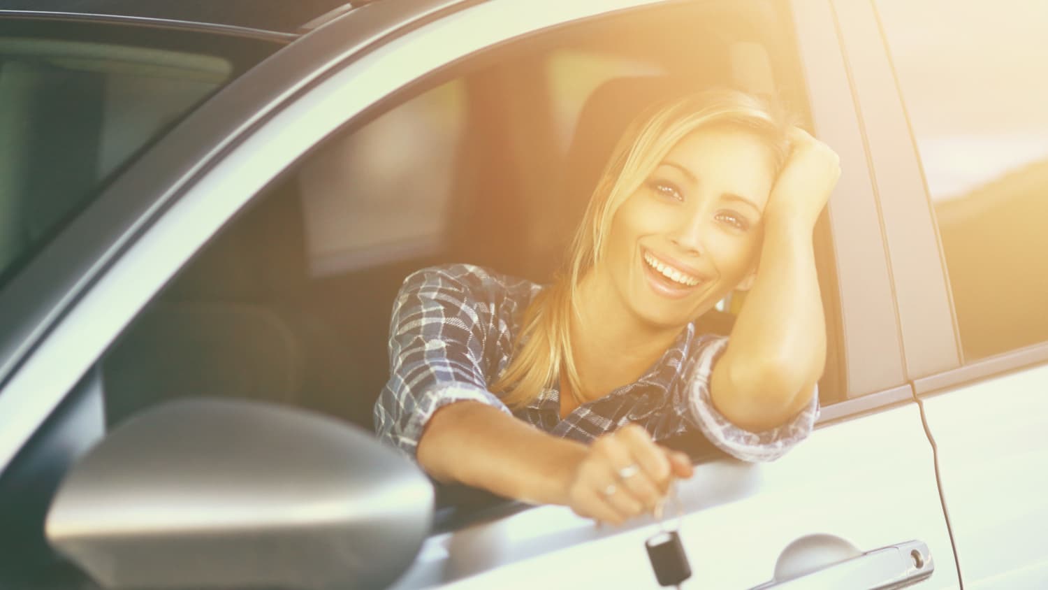Autofahrerin sitzt lächelnd in silberem Auto, nachdem sie die vario-finanzierung beim autokauf verwendet hat