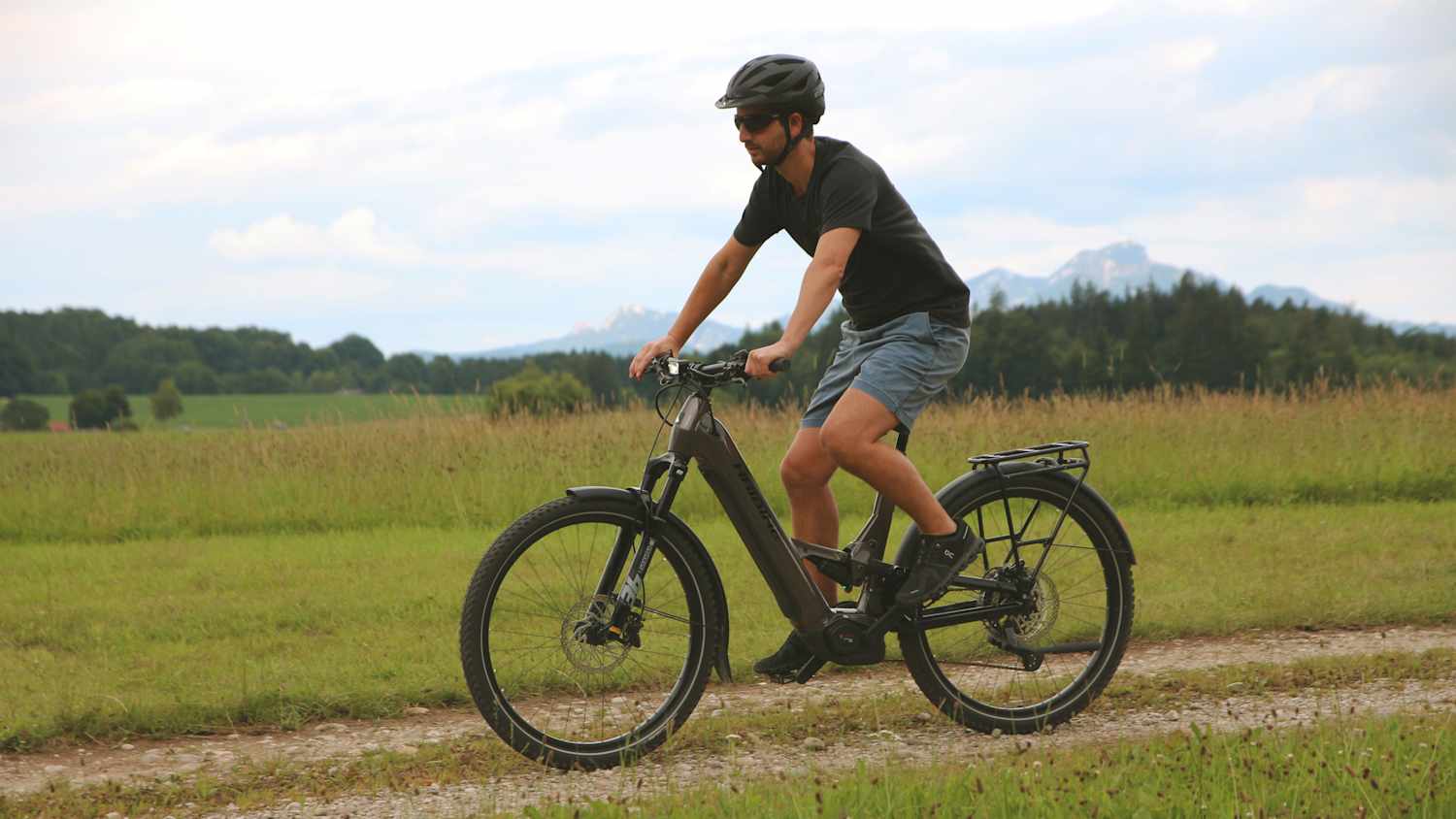 Ein Mann fährt auf einem E-Bike-Haibike ADVENTR 10 auf einem Feldweg