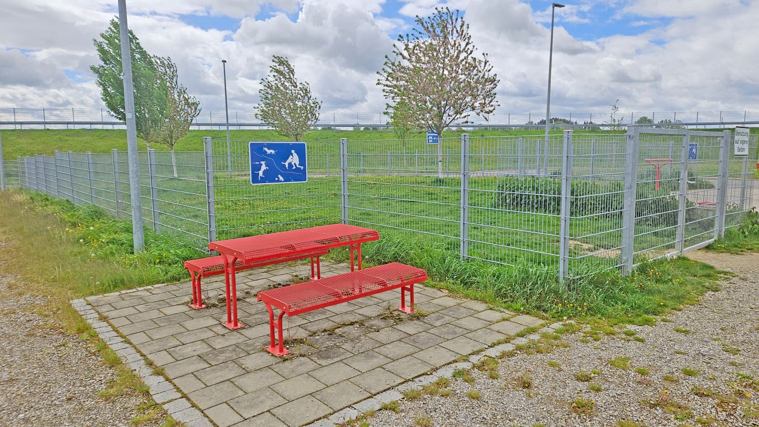 Eine eingezäunte Hundeauslauf-Wiese an einem Rasthof