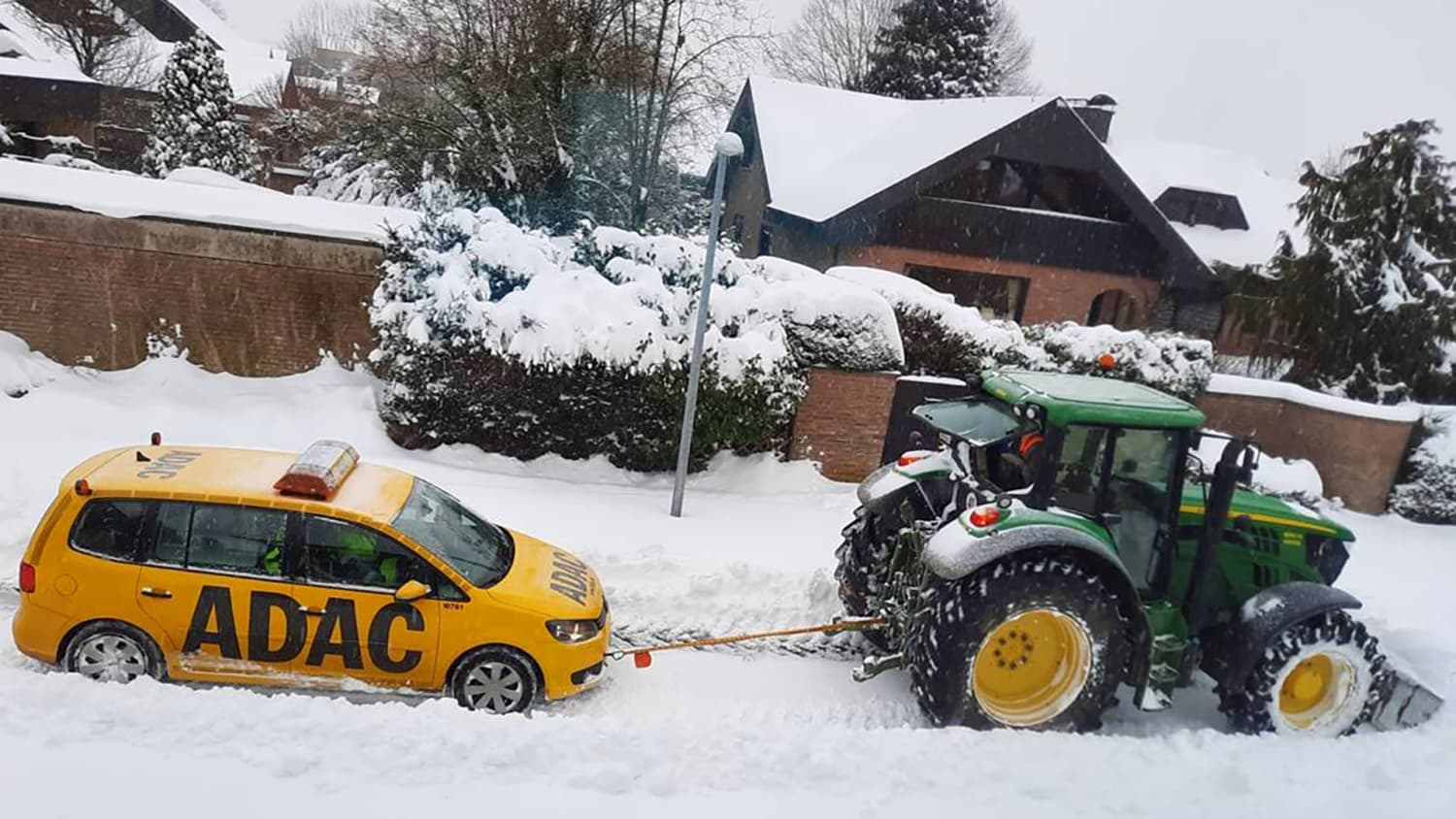 Im Schneechaos schlecht ein Traktor ein ADAC Straßenwachtauto ab