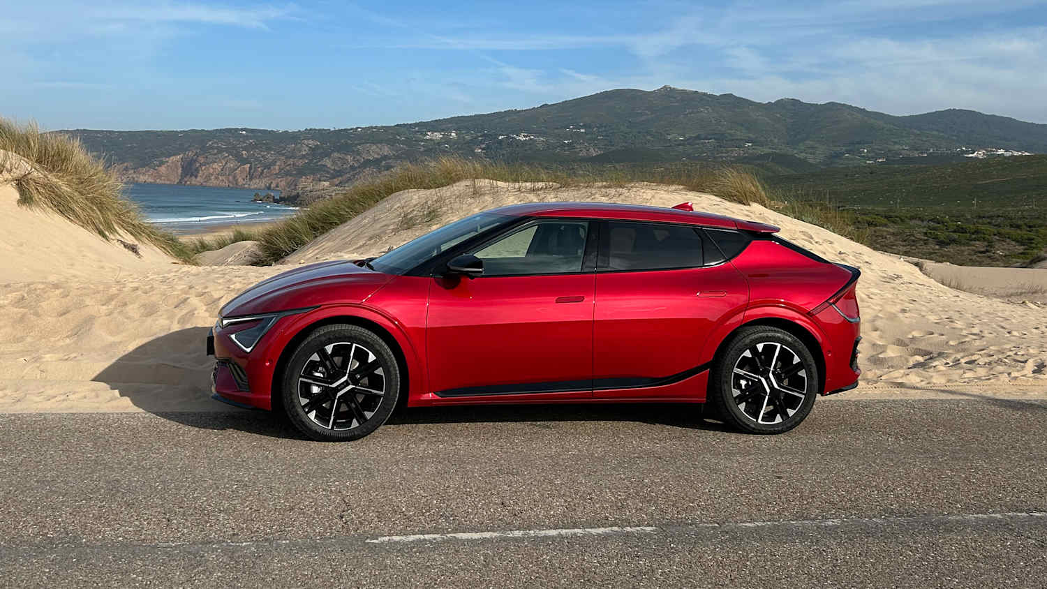 Seitenansicht eines Kia EV6 der vor einer Düne steht