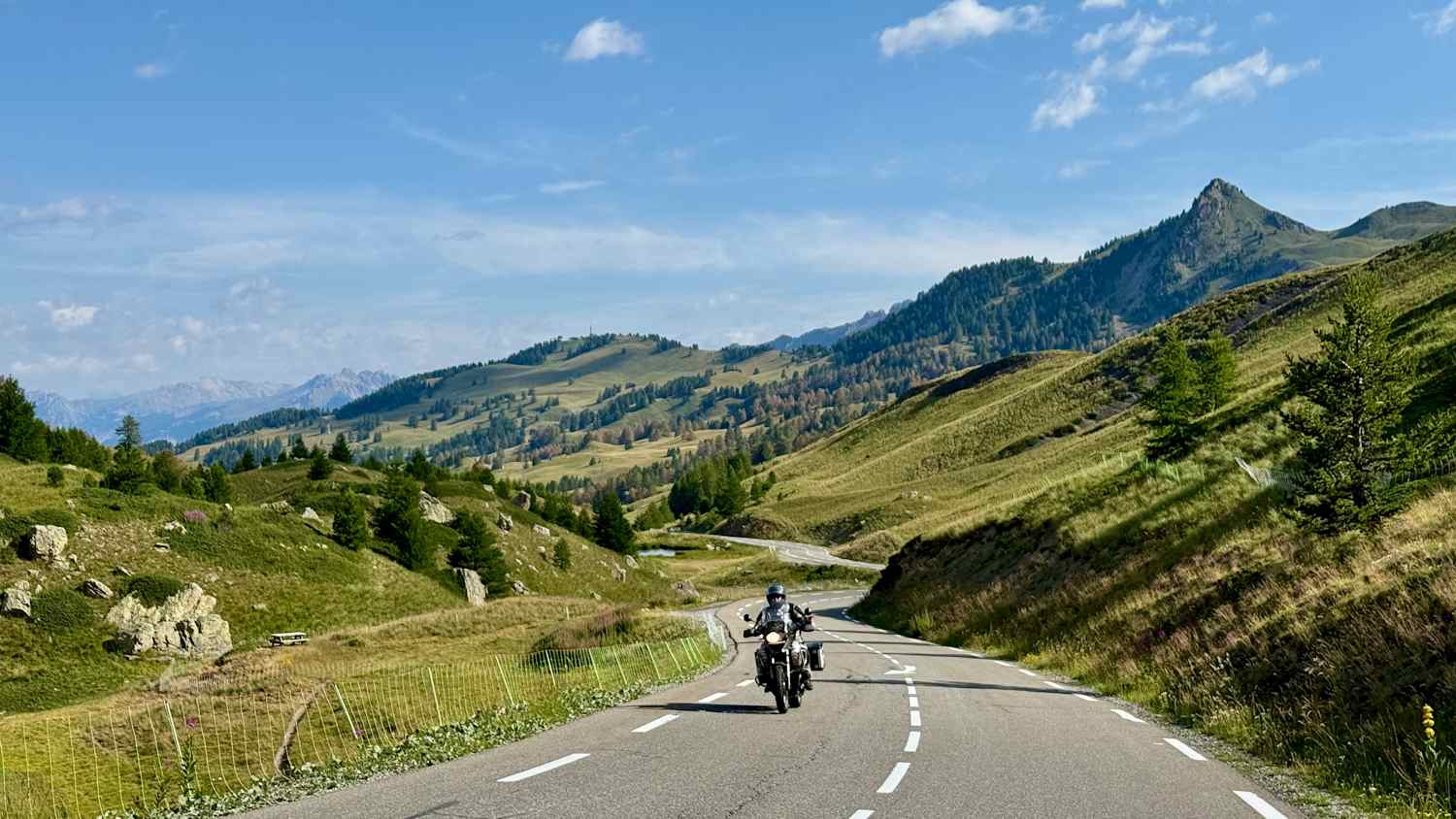 Motorradfahrer fährt auf der Nordseite des Col de Vars mit offener Berglandschaft, klassische Motorradtour
