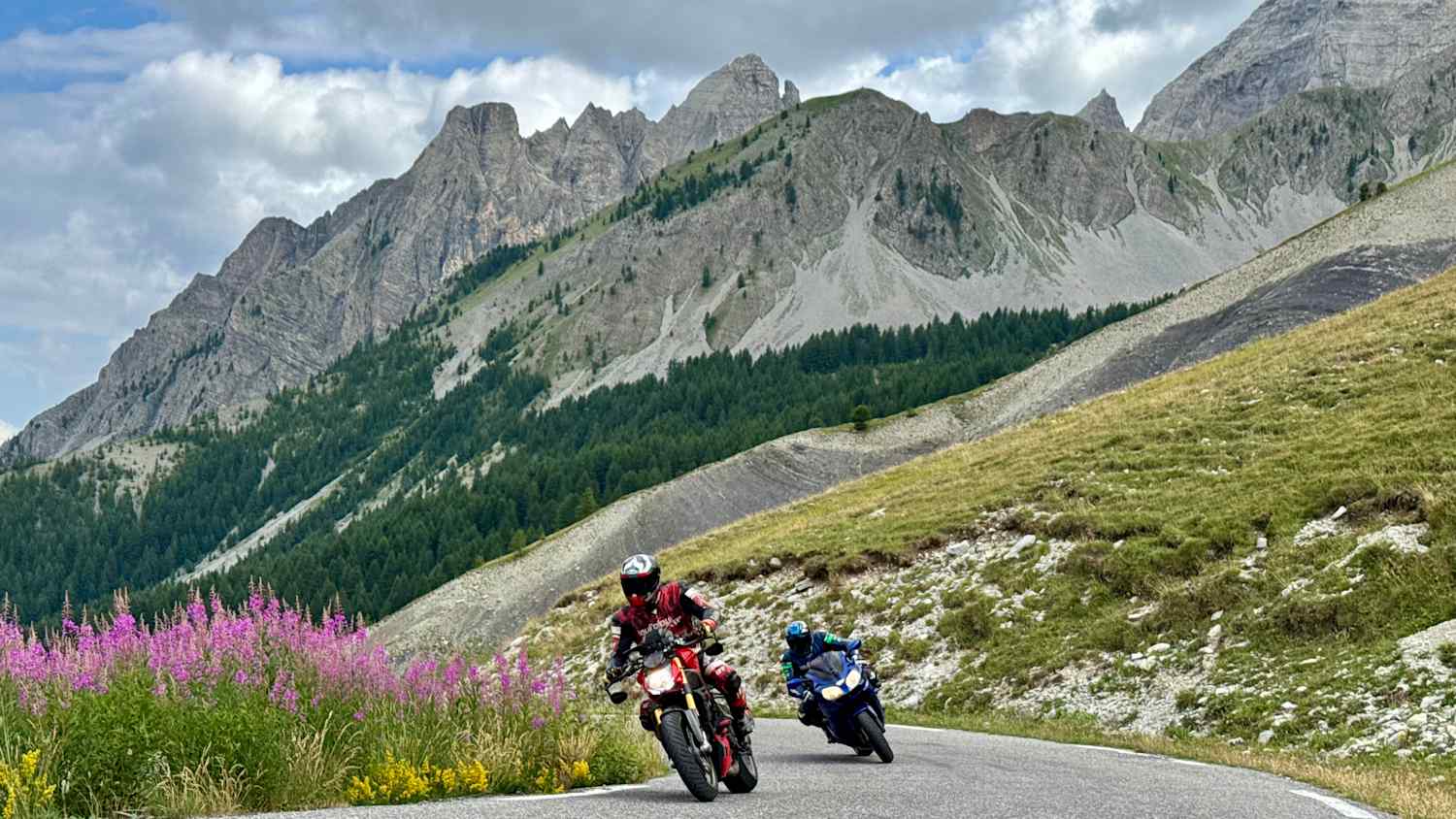 Motorradfahrer auf einer Straße am Col des Champs