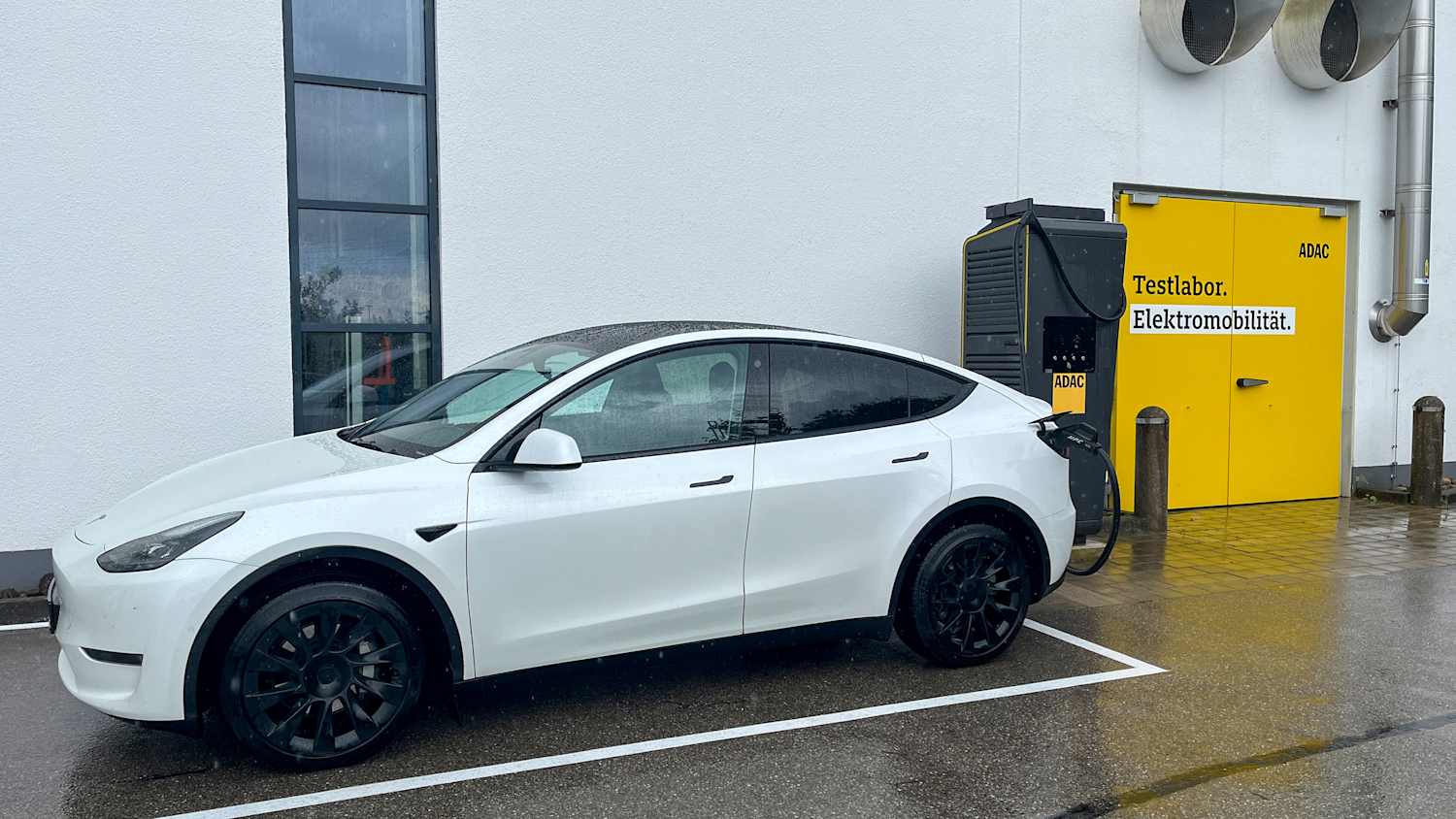 Ein Tesla Model Y steht an einer Schnellladesäule des ADAC