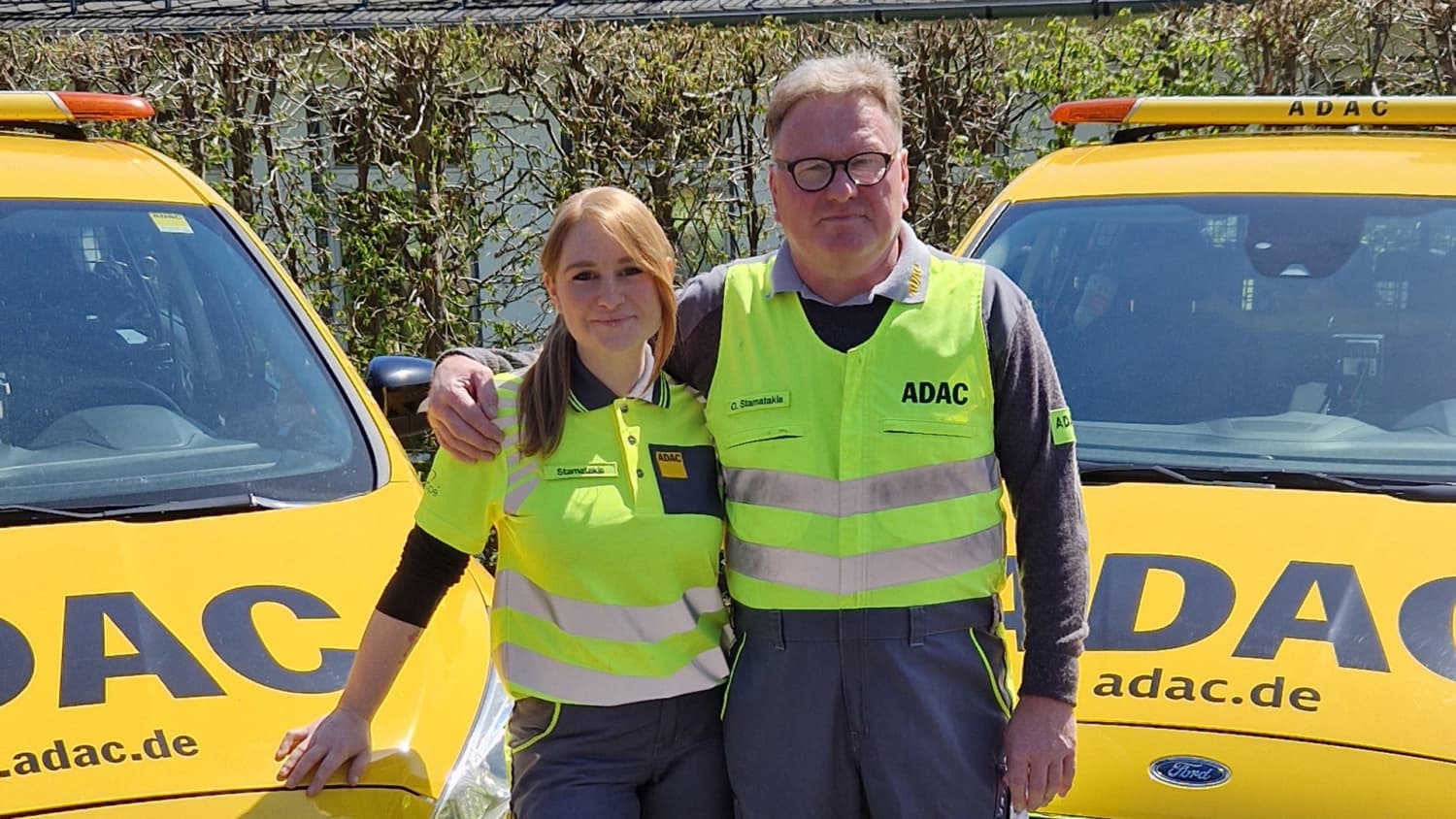 Straßenwachtfahrerin Annalena Stamatakis mit einem Kollegen vor einem ADAC Straßenwachtfahrzeug