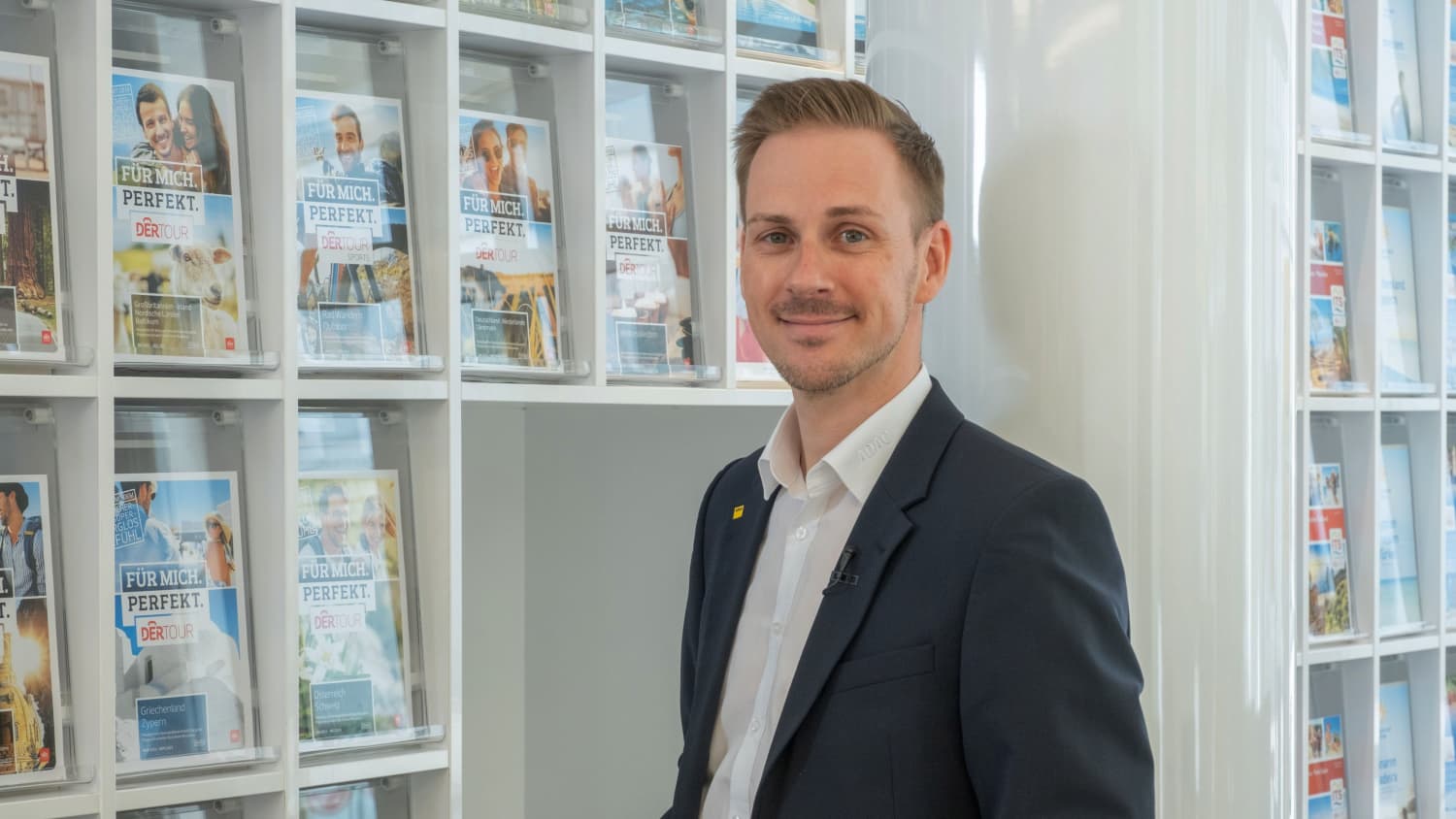 Markus Elter, Geschäftsstellenleiter ADAC Südbayern, vor einem Flyer und Zeitschriften-Display