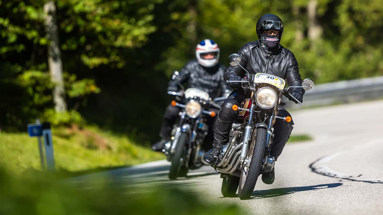 Zwei Motorradfahrer fahren auf einer Straße