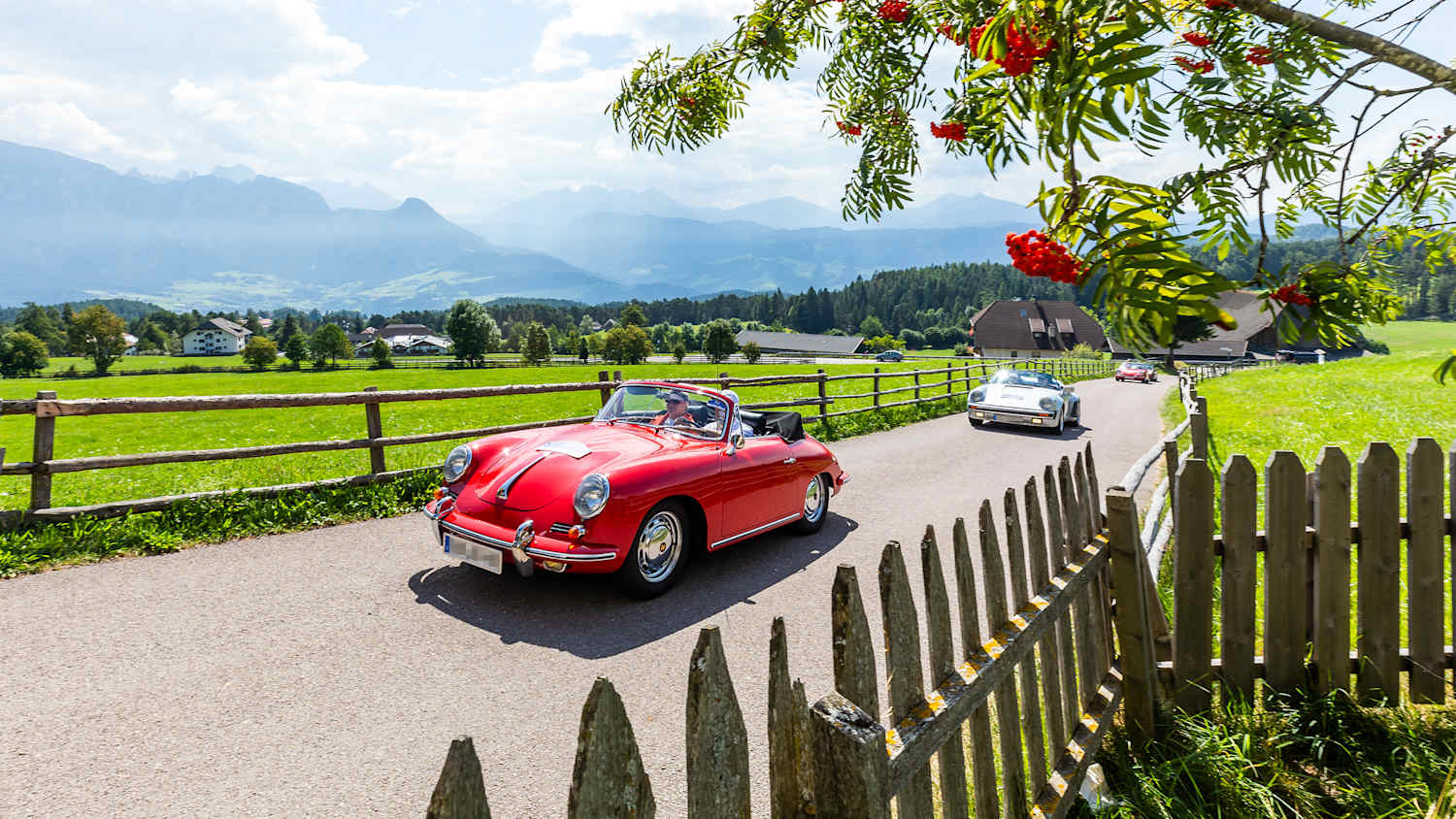 Zwei Oldtimer fahren auf einer Landstraße