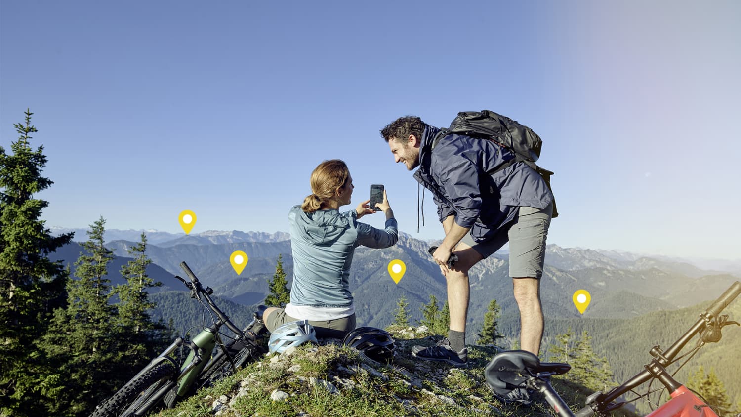 Mann und Frau nutzen Smartphone auf Berggipfel
