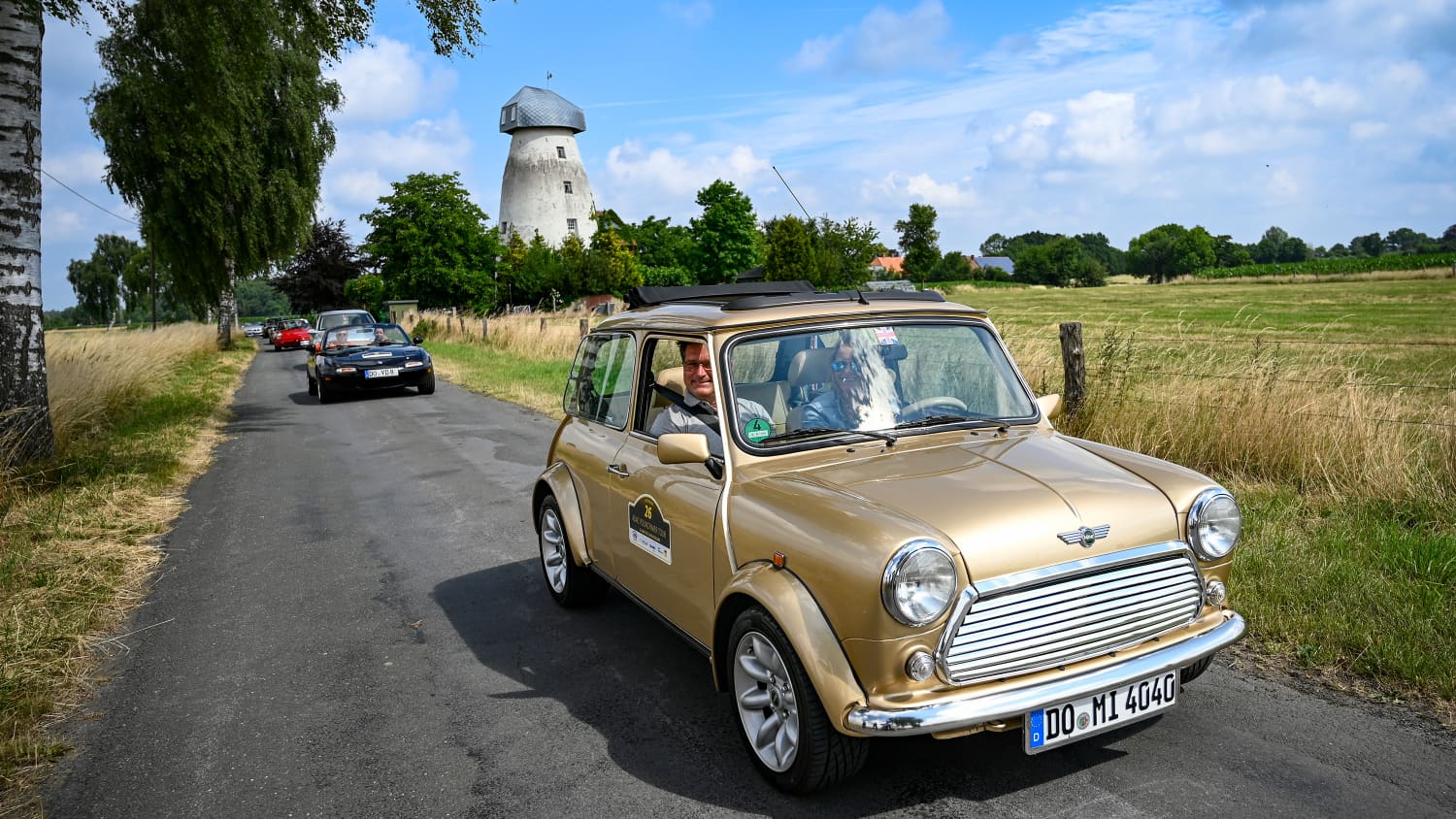 Oldtimer fahren auf einer Straße während der ADAC Youngtimer Tour
