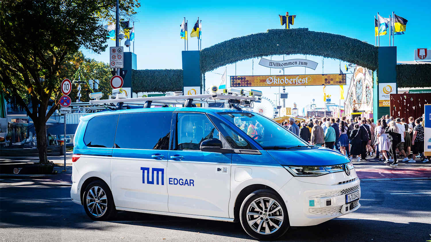 Ein autonom fahrfähiger VW Bus vor dem Eingang des Oktoberfestes 2024