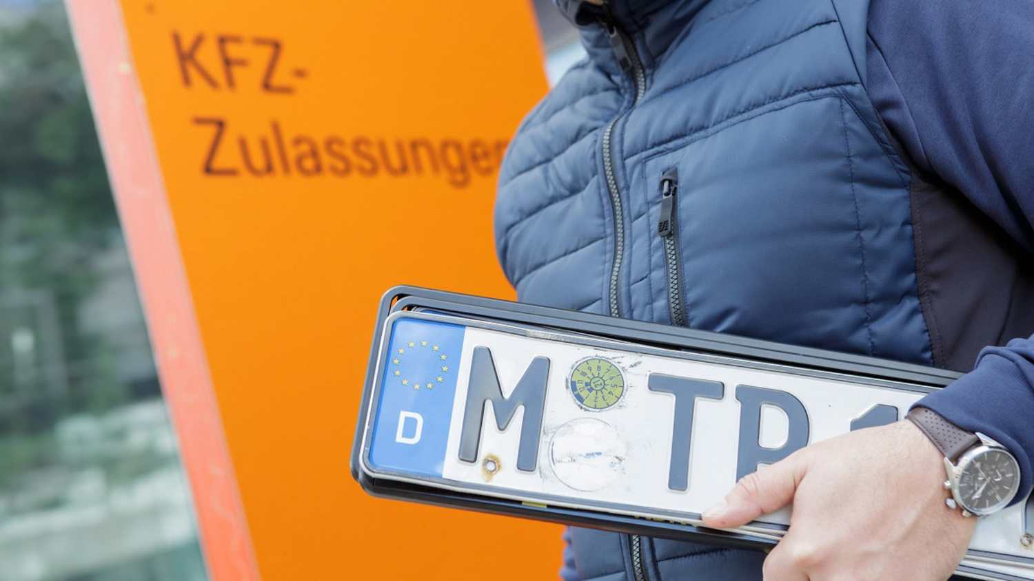 Eine Frau geht zur KFZ-Zulassungsstelle um ein Auto umzumelden