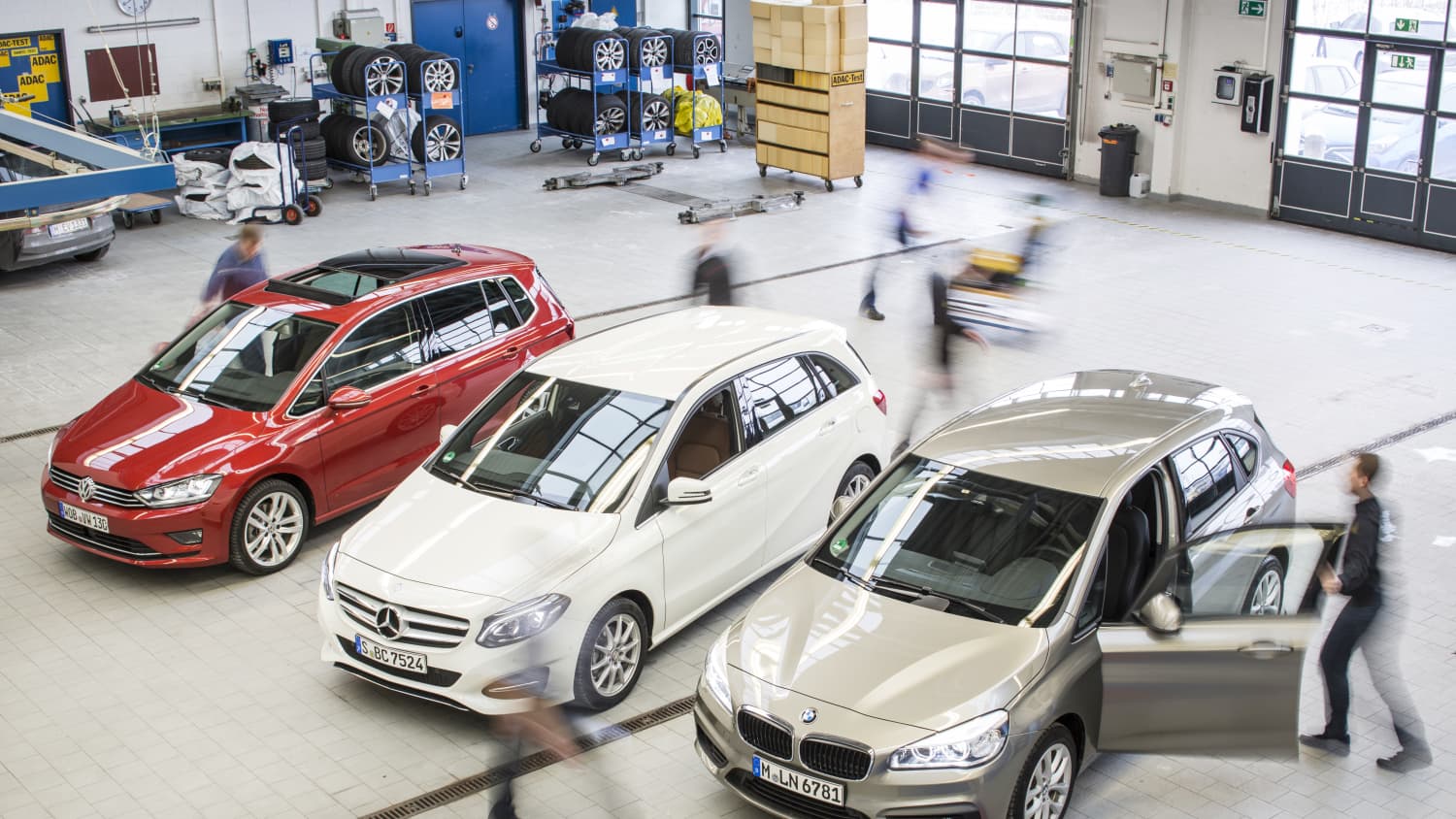 Drei Autos stehen in einer Halle