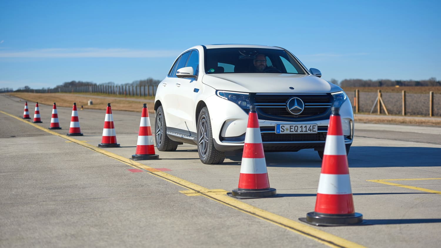 Mercedes EQC fährt neben Pylonen