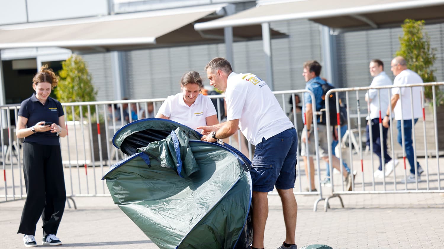 Teilnehmer des Camper des Jahres falten ein Zelt