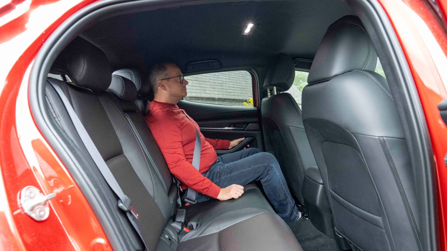 ADAC Redakteur Jochen Wieler sitzt auf der Rückbank im Mazda 3