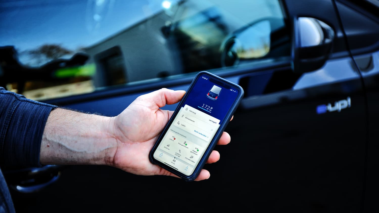 Ein Handy mit Informationen zum e-up im Hintergrund