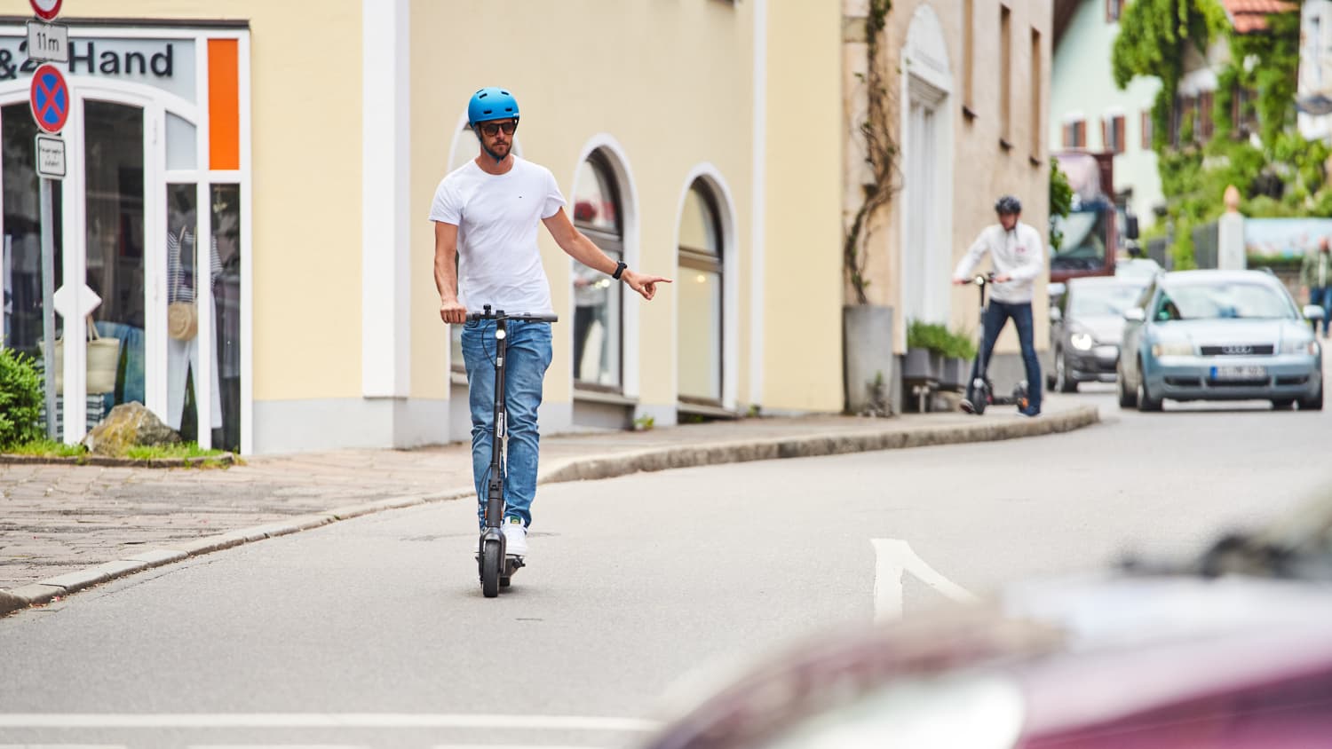 E-Scooter Fahrer gibt Handzeichen zum Abbiegen