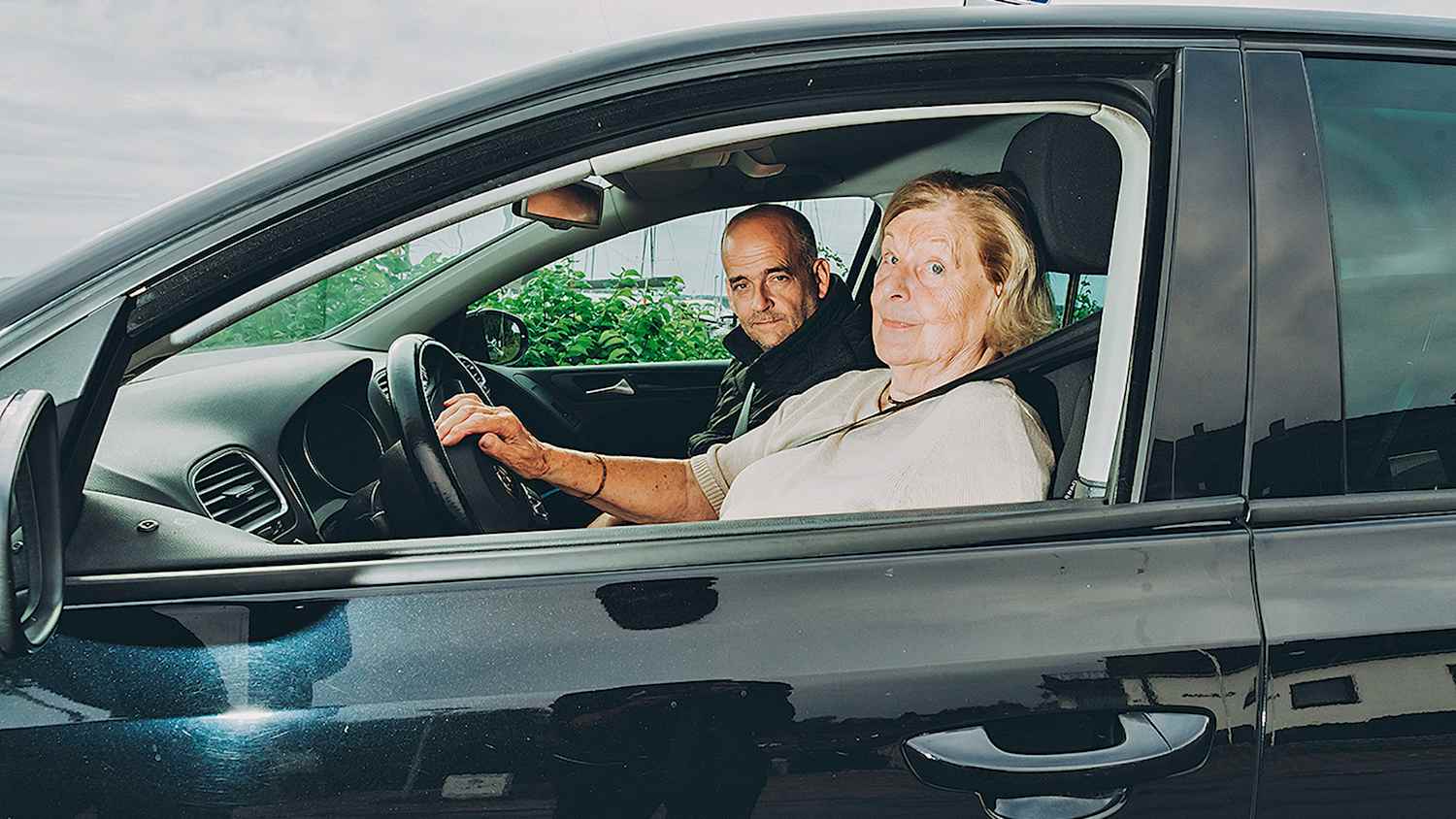 Eine Seniorin beim Fahr-Fitness-Check mit ihrem Fahrlehrer im Auto