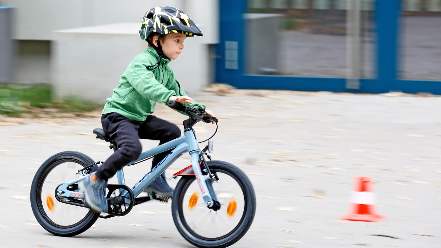 Ein Junge fährt auf einem 16 Zoll Fahrrad auf eine Pylone zu